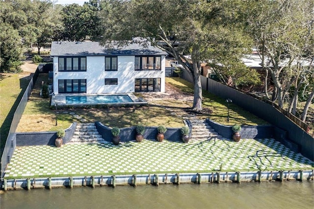 rear view of property featuring a patio, a water view, and a fenced backyard