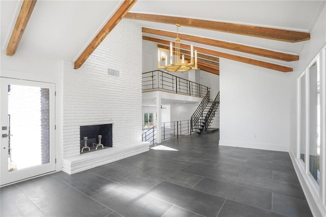 unfurnished living room with visible vents, a brick fireplace, high vaulted ceiling, beamed ceiling, and stairs