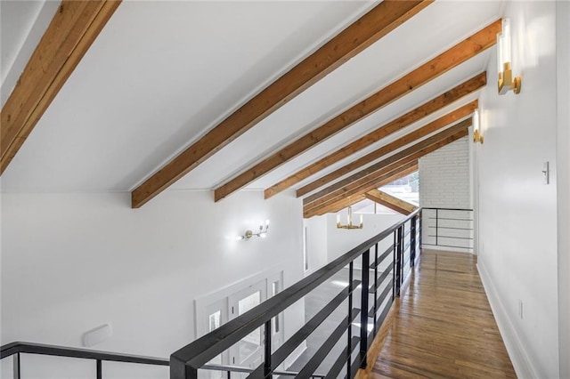 hallway with vaulted ceiling with beams, a notable chandelier, wood finished floors, and baseboards