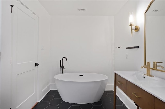 full bath with a soaking tub, visible vents, vanity, baseboards, and tile patterned floors