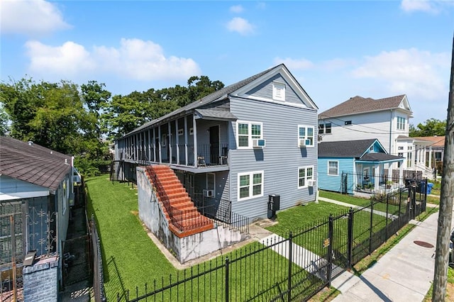 back of property featuring stairs, a lawn, and a fenced front yard