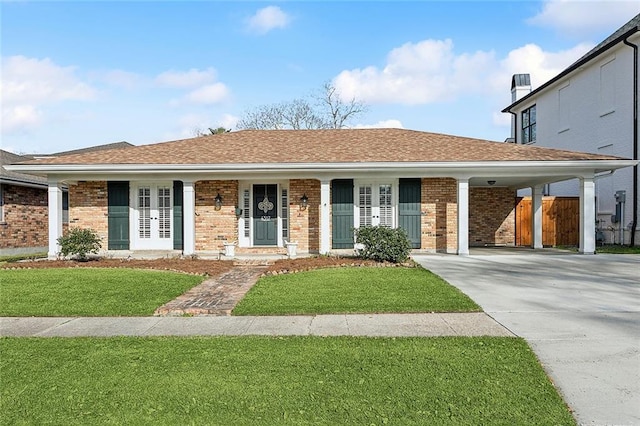 ranch-style house with a front yard, concrete driveway, and brick siding