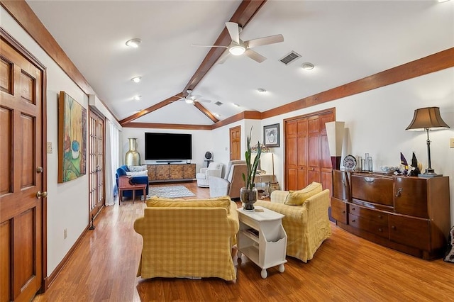 living room featuring baseboards, visible vents, lofted ceiling with beams, ceiling fan, and wood finished floors