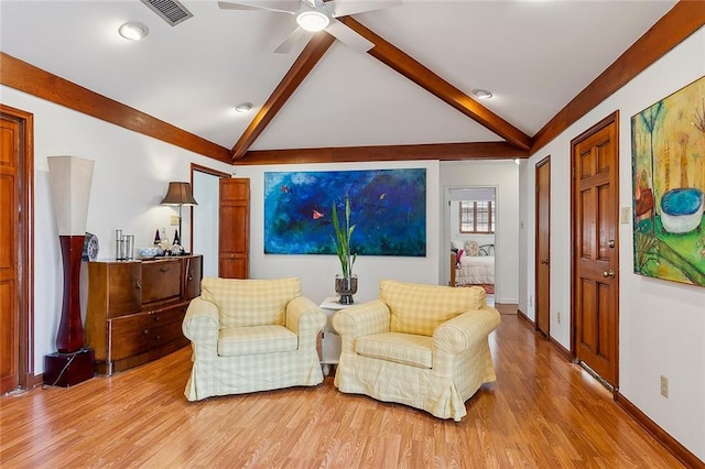 sitting room featuring lofted ceiling with beams, light wood-type flooring, visible vents, and baseboards