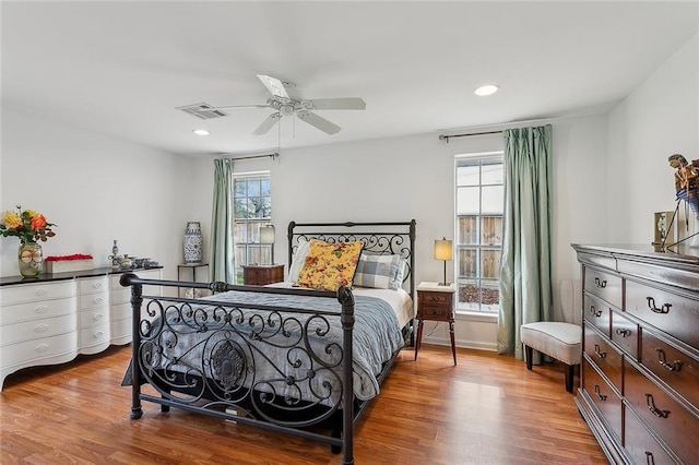 bedroom with multiple windows, wood finished floors, visible vents, and recessed lighting