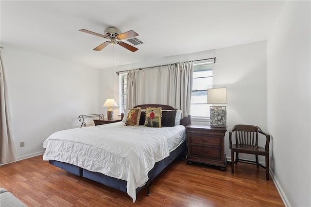 bedroom featuring visible vents, baseboards, and wood finished floors