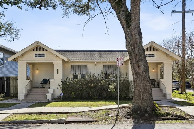 view of front of property with a shingled roof and fence