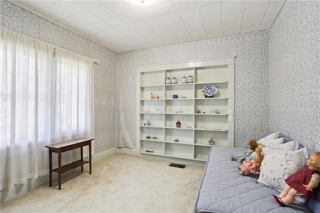 bedroom with visible vents, light colored carpet, and wallpapered walls