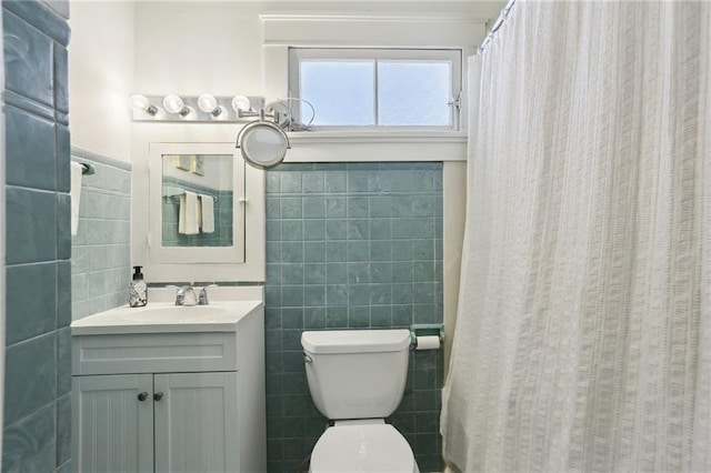 full bathroom with toilet, vanity, and tile walls