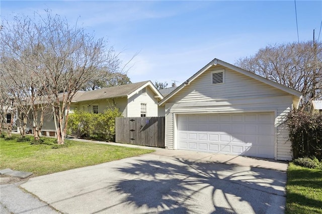 view of front of house featuring a front yard, a detached garage, an outbuilding, and fence