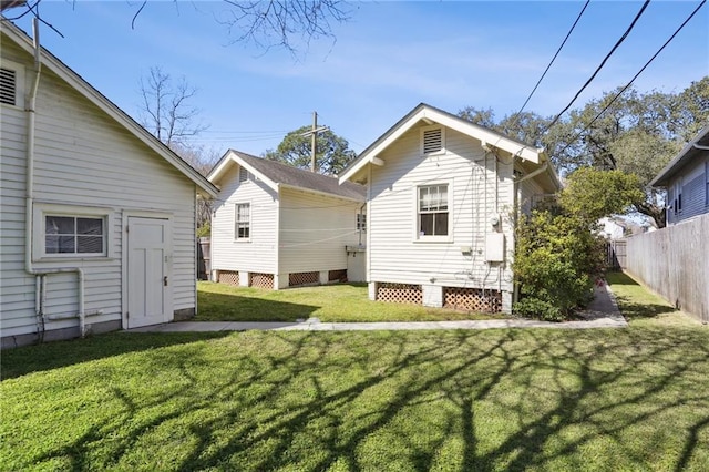 rear view of property with fence and a yard