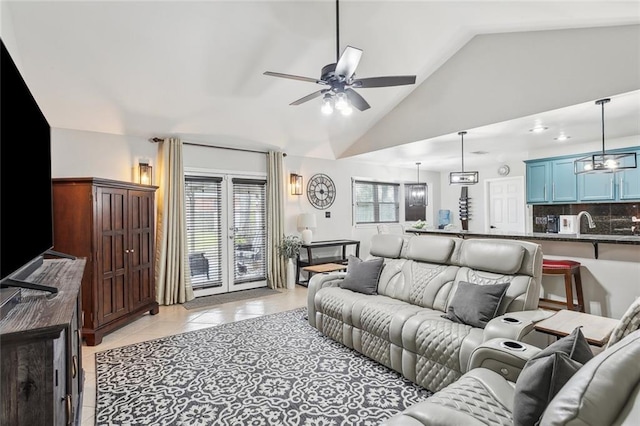 living area with a ceiling fan, vaulted ceiling, and light tile patterned floors