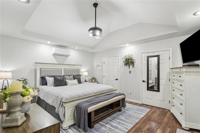 bedroom with lofted ceiling, a tray ceiling, dark wood-type flooring, and a wall mounted AC