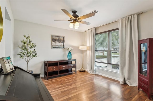 sitting room featuring visible vents, wood finished floors, a ceiling fan, and baseboards