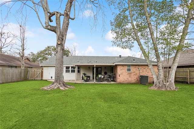 rear view of house with a fenced backyard, cooling unit, brick siding, a lawn, and a patio area