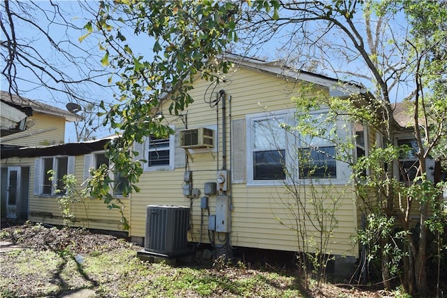 view of property exterior featuring a wall unit AC and central air condition unit