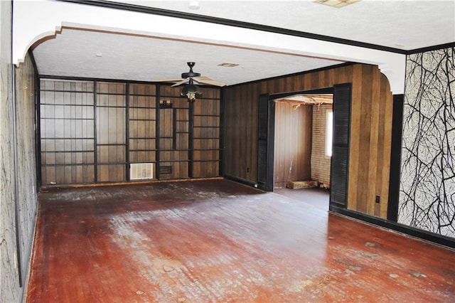 unfurnished living room featuring visible vents, crown molding, and wood finished floors