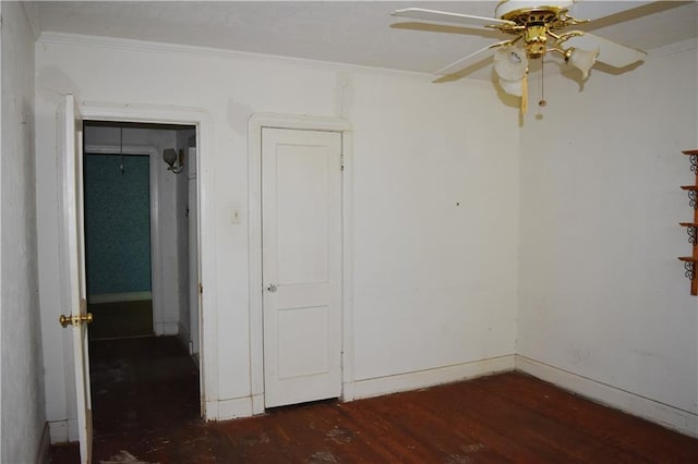 empty room with baseboards, wood finished floors, a ceiling fan, and crown molding