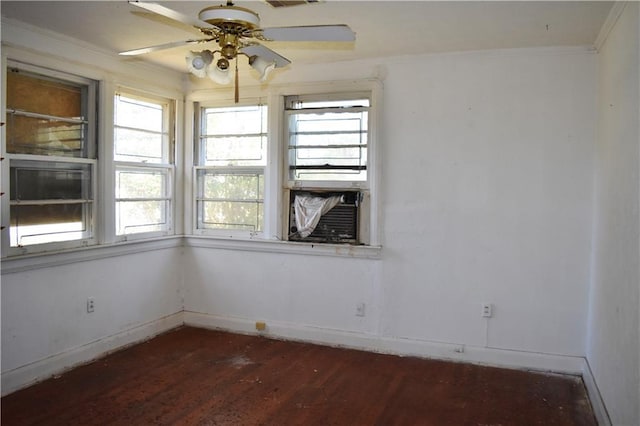 unfurnished room with crown molding, visible vents, ceiling fan, wood finished floors, and baseboards