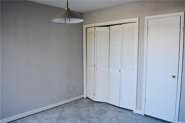 unfurnished bedroom featuring a closet and baseboards