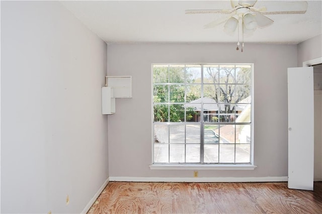 spare room featuring baseboards, a wealth of natural light, and wood finished floors