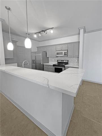 kitchen with a peninsula, appliances with stainless steel finishes, backsplash, gray cabinets, and decorative light fixtures