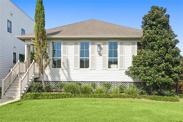 view of front of property with crawl space, a front lawn, and a shingled roof