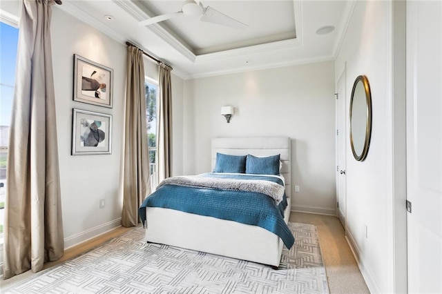 bedroom with baseboards, a raised ceiling, a ceiling fan, and crown molding