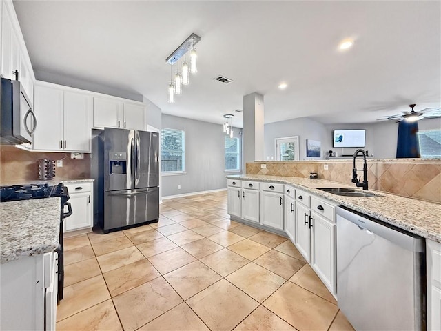 kitchen with stainless steel appliances, backsplash, a sink, and visible vents