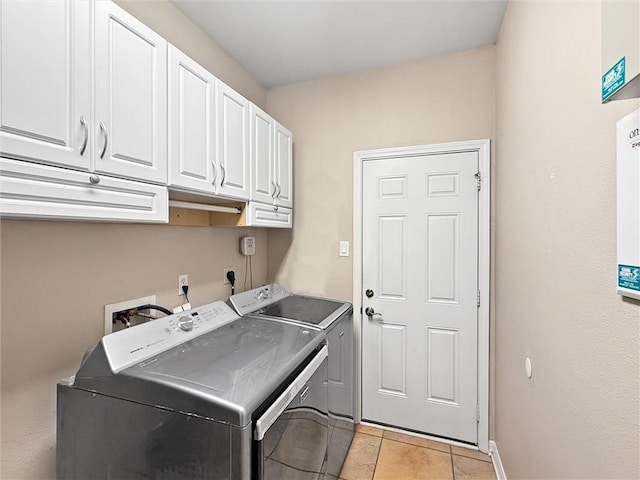 clothes washing area featuring cabinet space, washing machine and dryer, and baseboards