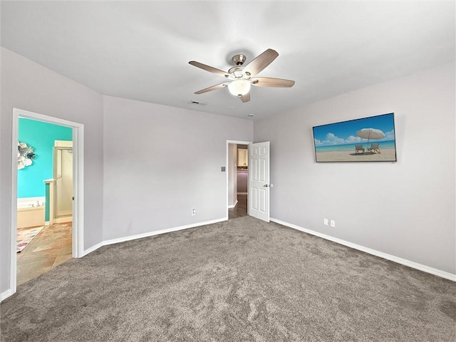 carpeted spare room featuring baseboards, visible vents, and a ceiling fan