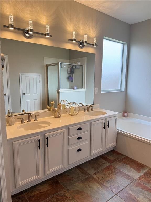 533 Moore Blvd, Covington, LA 70433 - bathroom featuring double vanity, a garden tub, and stone tile floors
