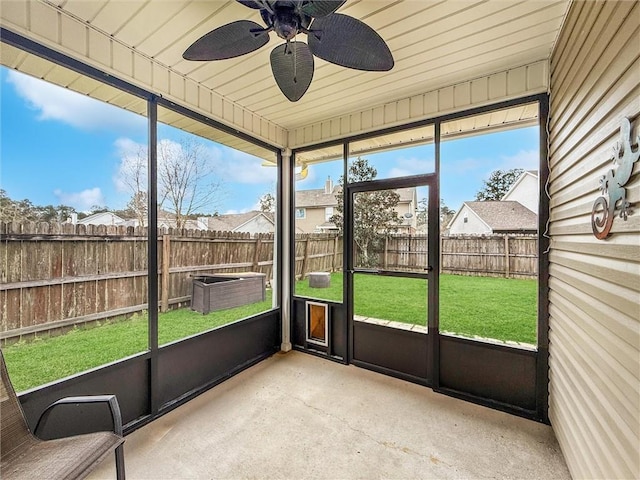 unfurnished sunroom featuring a ceiling fan