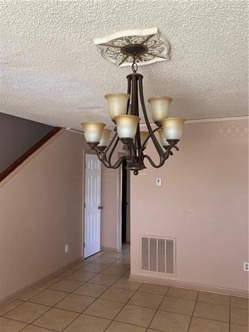 interior space featuring a textured ceiling, visible vents, and a notable chandelier