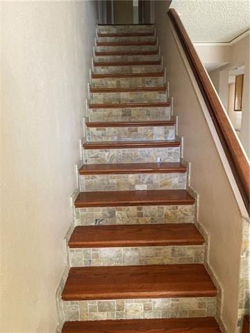 stairs with a textured ceiling