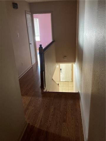 corridor with baseboards and wood finished floors