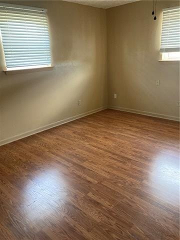 empty room featuring wood finished floors and baseboards