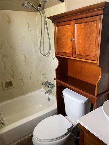 full bathroom with bathing tub / shower combination, toilet, and vanity