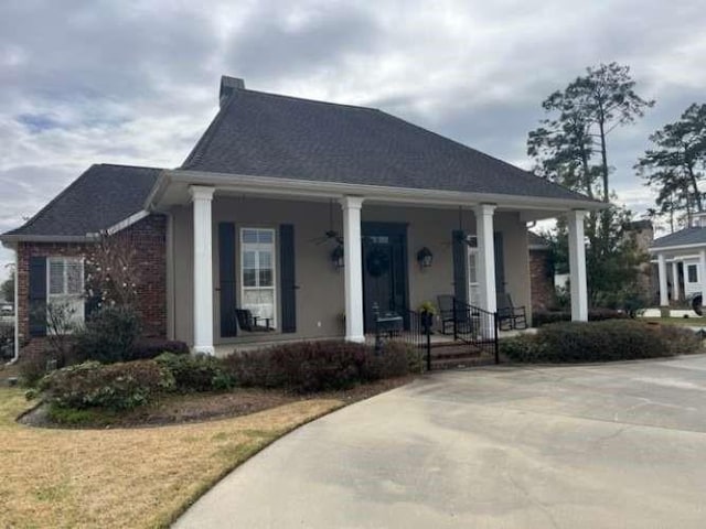 view of front of home featuring covered porch and brick siding