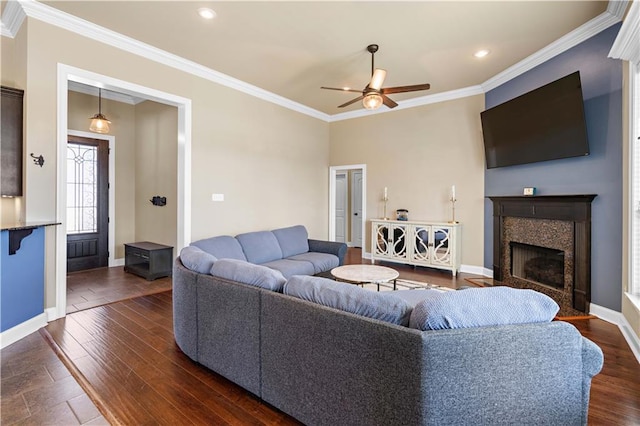 living room featuring baseboards, dark wood-style flooring, a fireplace, and crown molding