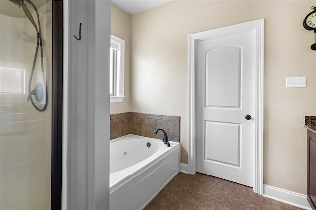 full bath featuring a garden tub, baseboards, walk in shower, and vanity