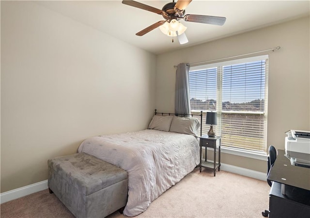 bedroom with a ceiling fan, light carpet, and baseboards