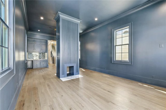 empty room featuring baseboards, recessed lighting, light wood-style flooring, and crown molding