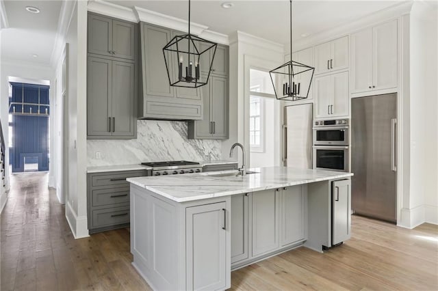 3324 Camp St, New Orleans, LA 70115 - kitchen with a chandelier, appliances with stainless steel finishes, gray cabinets, ornamental molding, and light wood-style floors