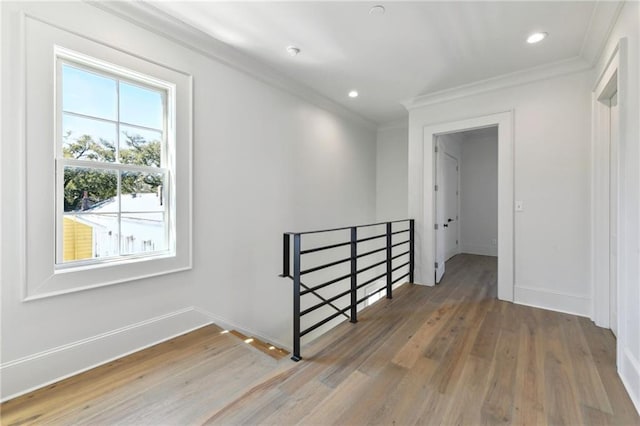 unfurnished room featuring ornamental molding, recessed lighting, wood finished floors, and baseboards