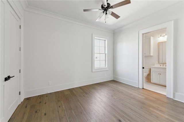 unfurnished bedroom with light wood-style floors, ornamental molding, and baseboards