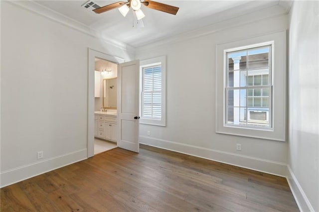 unfurnished bedroom featuring baseboards, wood finished floors, and crown molding