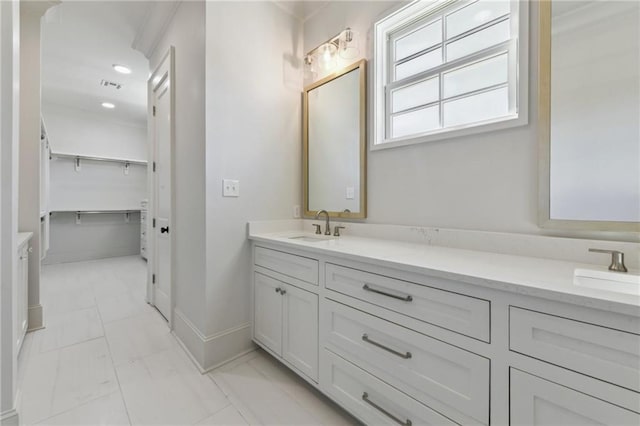 3324 Camp St, New Orleans, LA 70115 - bathroom featuring double vanity, marble look tile flooring, baseboards, and recessed lighting