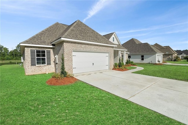 view of front of house with driveway, a shingled roof, an attached garage, and a front yard