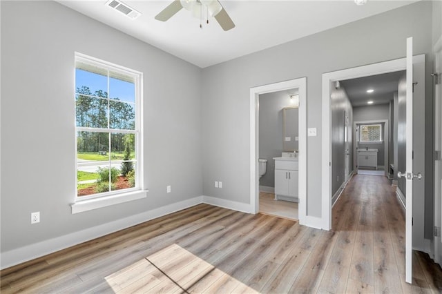 unfurnished bedroom featuring light wood-type flooring, baseboards, multiple windows, and visible vents